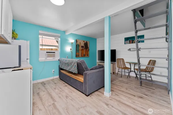 a living room with furniture and a refrigerator