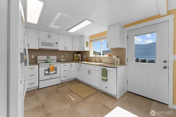 a kitchen with white cabinets and white appliances