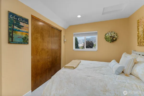 a bedroom with a bed and a painting on the wall