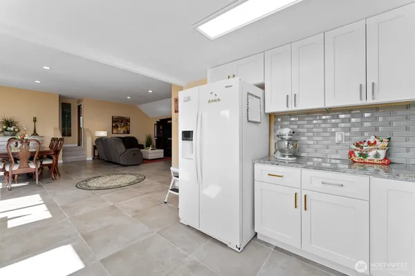 a kitchen with white cabinets and refrigerator