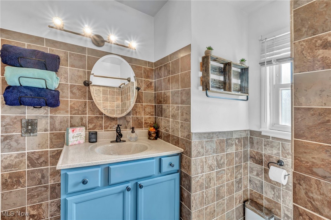 1641 Slusser Road Akron, OH 44305 - Photo 25 of 34 Full bathroom featuring tile walls, vanity, and wainscoting