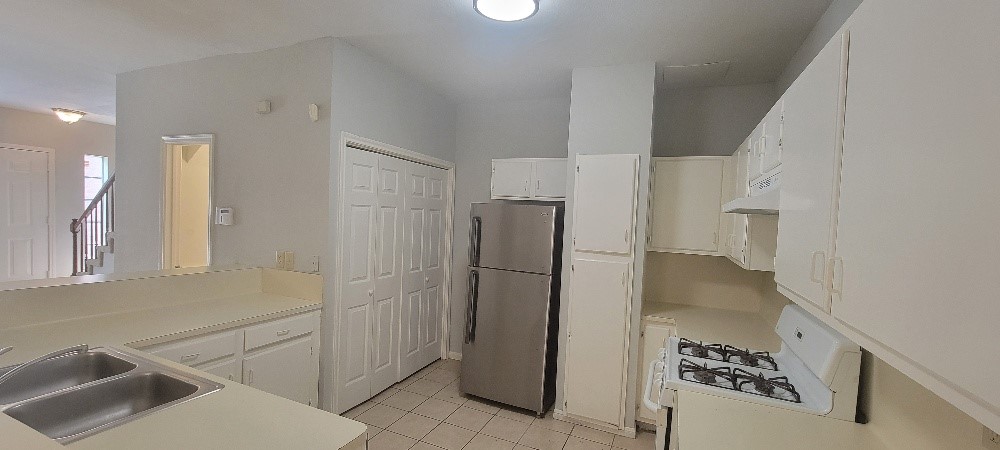 7023 Alabonson Road Houston, TX 77088 - Photo 4 of 13 a kitchen with a refrigerator and a sink