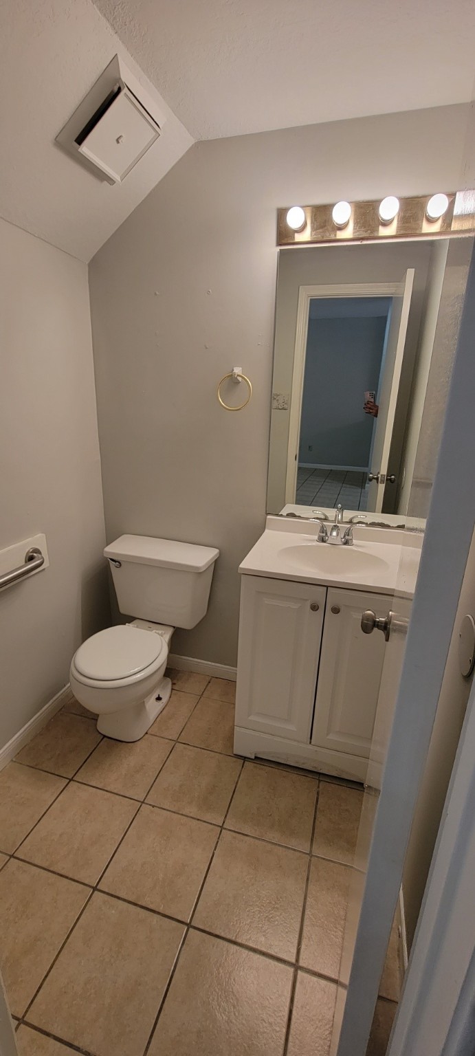 7023 Alabonson Road Houston, TX 77088 - Photo 6 of 13 a bathroom with a toilet a sink and mirror