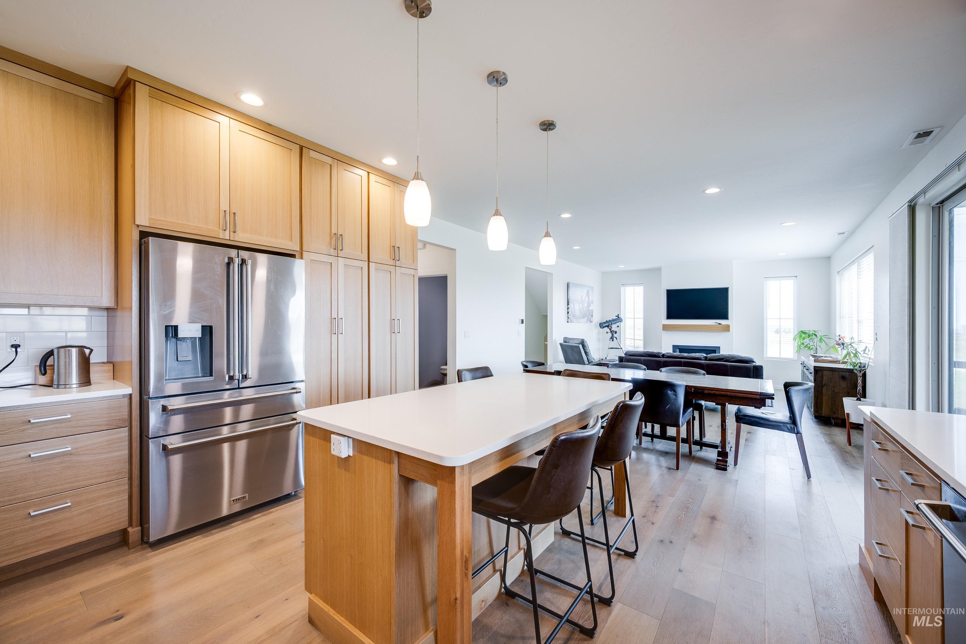 1325 Southwest Panorama Drive Pullman, WA 99163 - Photo 11 of 48 Kitchen featuring high quality fridge, light wood-style flooring, decorative light fixtures, backsplash, and recessed lighting