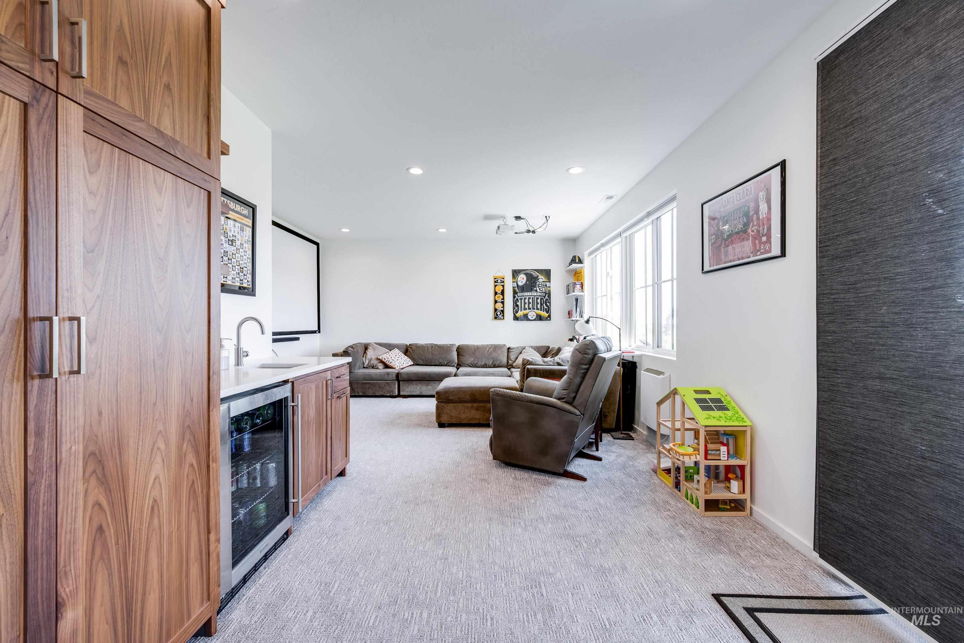 1325 Southwest Panorama Drive Pullman, WA 99163 - Photo 33 of 48 Living area featuring light carpet, beverage cooler, recessed lighting, and bar with sink