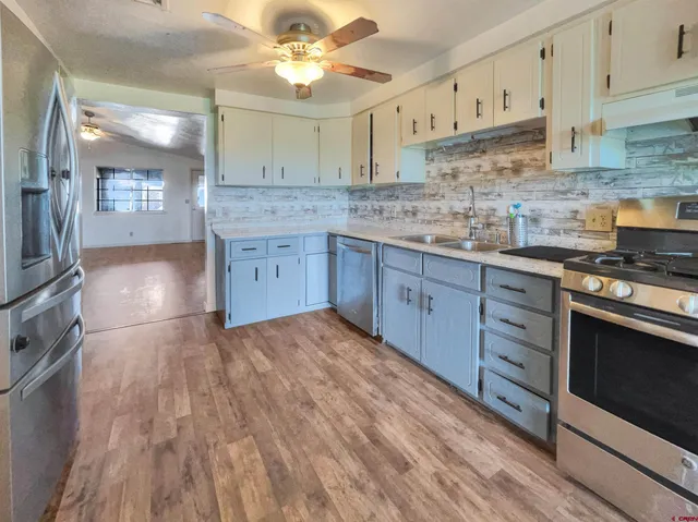 a kitchen with stainless steel appliances granite countertop a sink a stove and cabinets