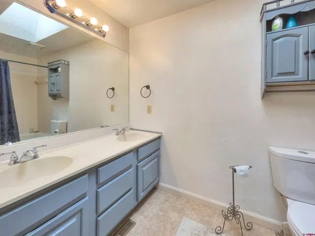 a bathroom with a granite countertop sink a toilet and a mirror