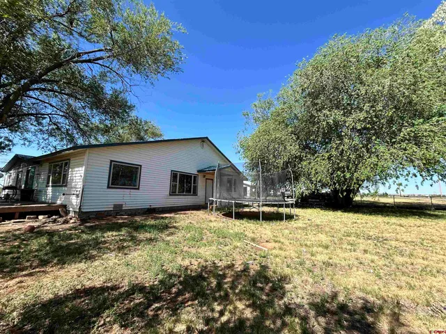 a backyard of a house with yard and outdoor seating