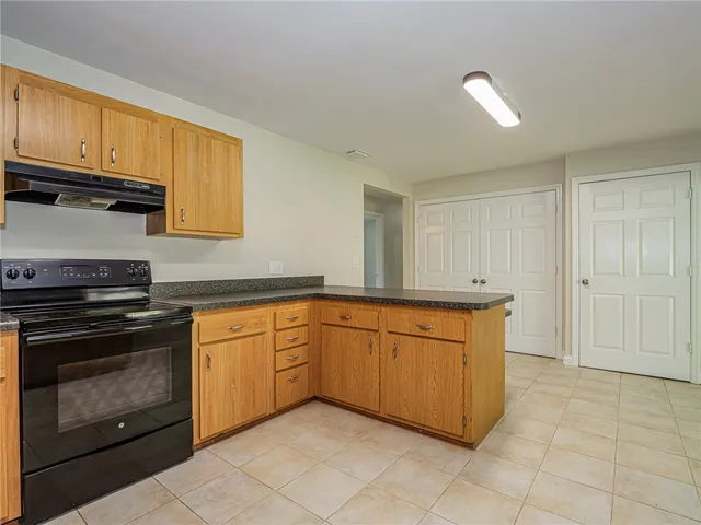 a kitchen with granite countertop a sink stove and cabinets