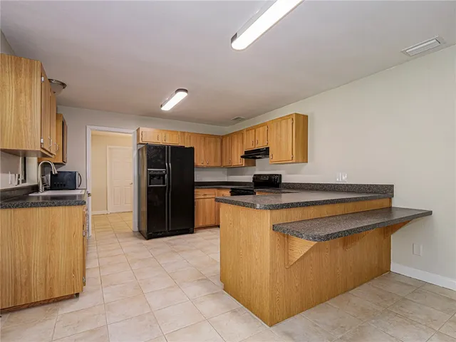 a kitchen with stainless steel appliances granite countertop a refrigerator and a stove top oven