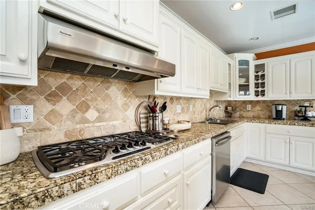 a kitchen with white cabinets and appliances