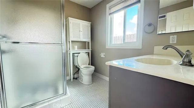 a bathroom with a granite countertop sink toilet and shower
