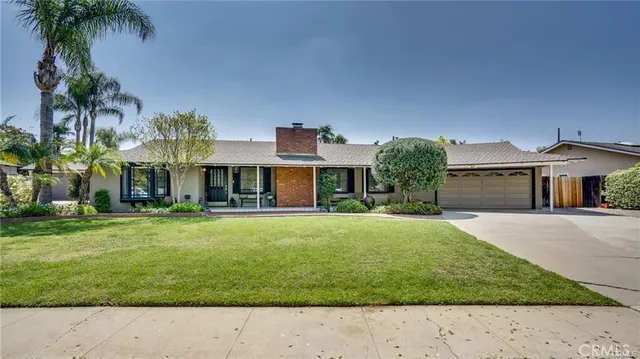 front view of a house with a yard and a garage