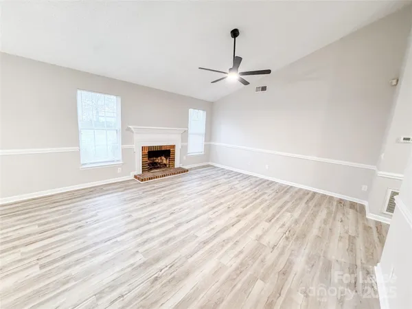 wooden floor fireplace and natural light in empty room