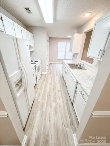 a view of a kitchen with wooden floor and electronic appliances