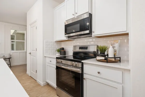 a kitchen with stainless steel appliances a stove a microwave oven cabinets and a counter space