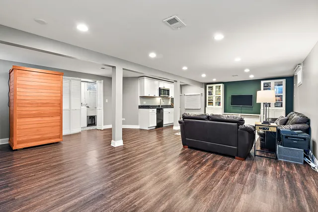 a living room with furniture and a wooden floor