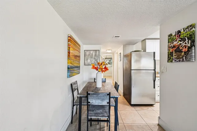 a dining room with furniture and a refrigerator