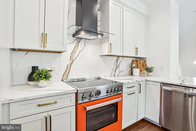 a kitchen with a stove a sink a dining table and chairs