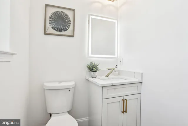 a bathroom with a granite countertop sink toilet a mirror and bathtub