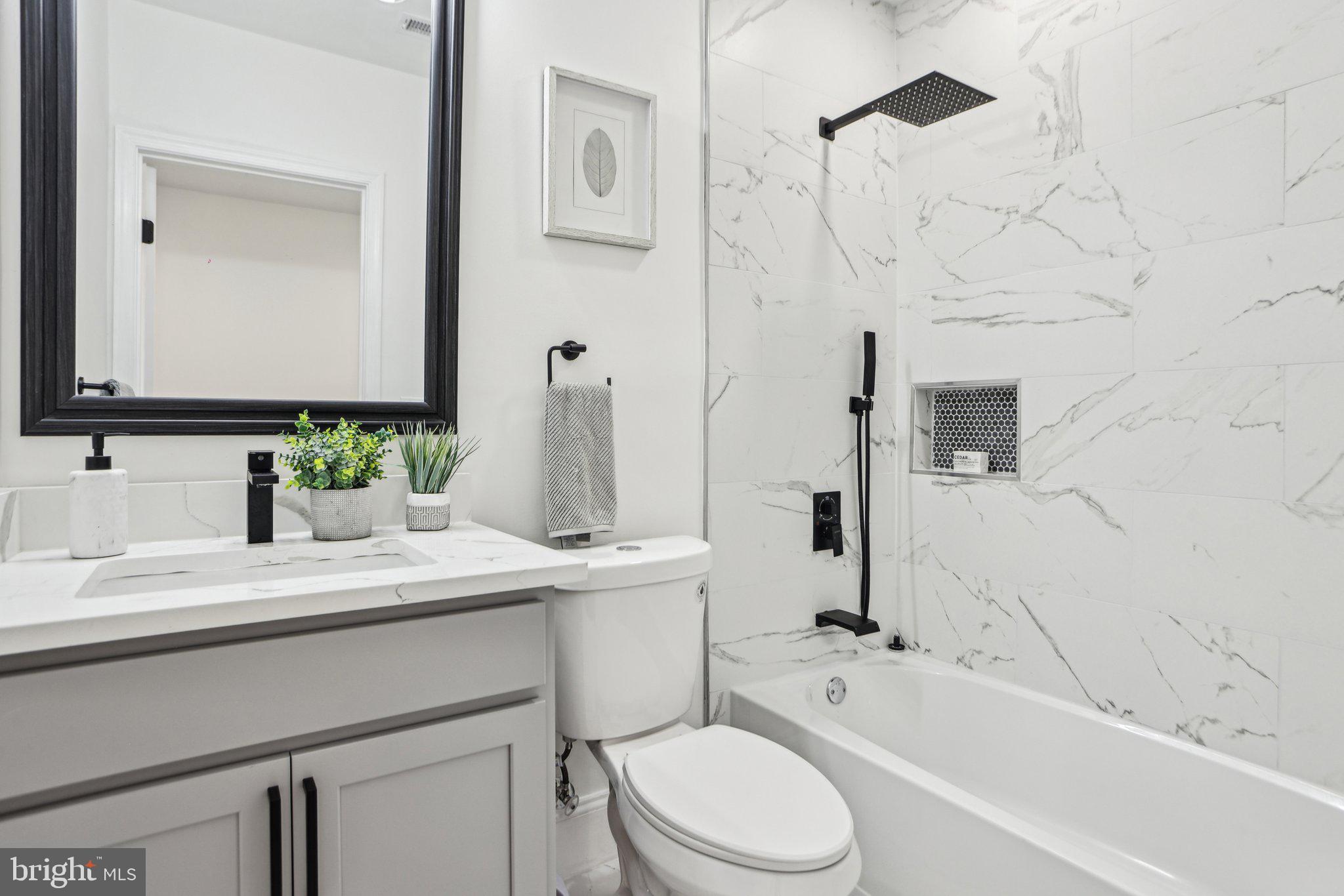 322 56th Street Northeast Washington, DC 20019 - Photo 42 of 57 a bathroom with a granite countertop sink toilet a mirror and bathtub