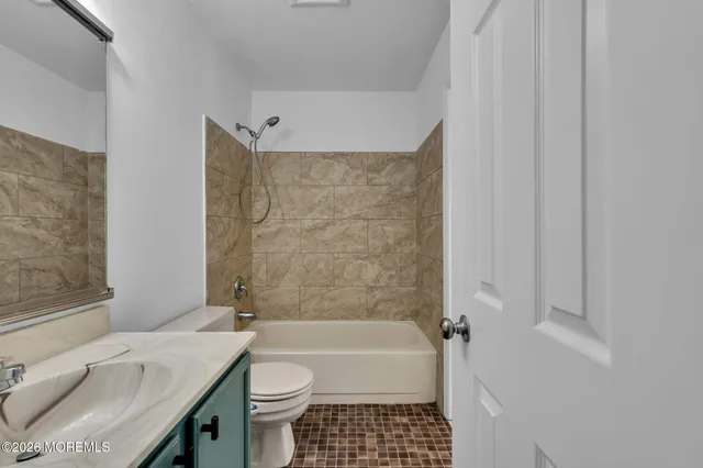 a bathroom with a granite countertop bathtub toilet and sink