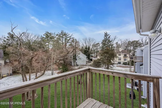 a balcony with view of trees in front of house