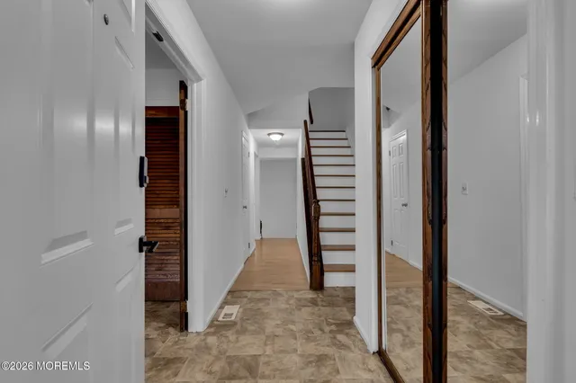 a view of a hallway with a door and stairs