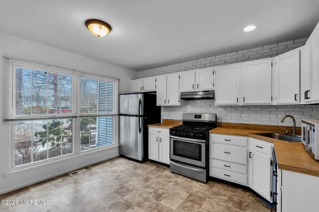 a kitchen with white cabinets and stainless steel appliances