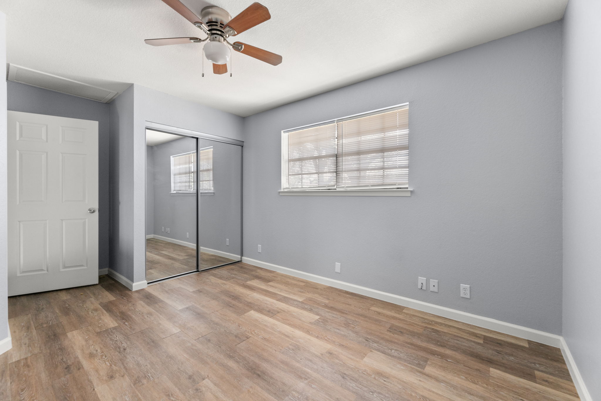 3802 Foust Trail, Unit A Georgetown, TX 78628 - Photo 24 of 34 A quiet bedroom with light wood flooring and a mirrored closet creates an inviting, adaptable personal space.