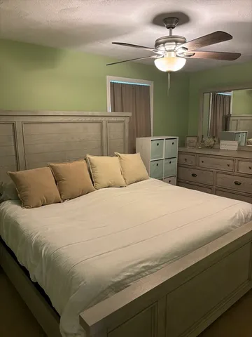 a bedroom with a large bed and a chandelier