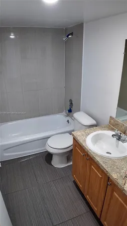 a bathroom with a granite countertop sink and mirror