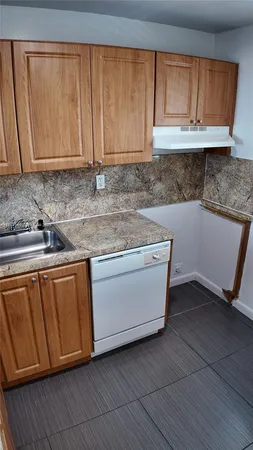 a kitchen with granite countertop cabinets sink and microwave