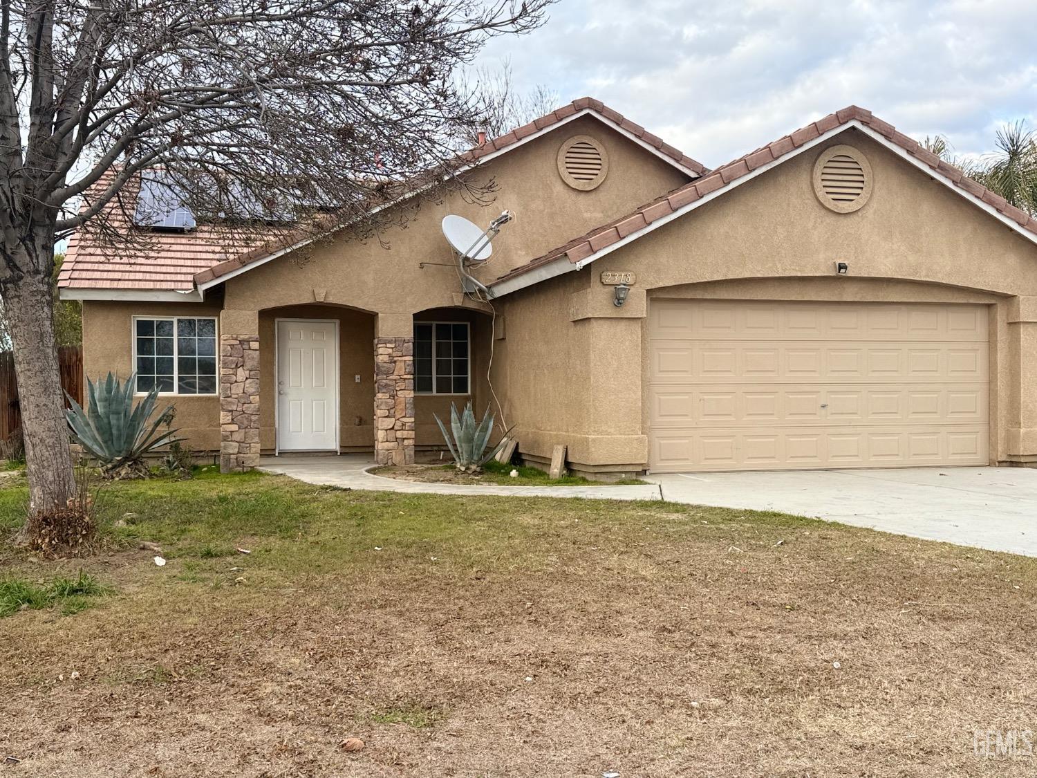 Undisclosed Address Bakersfield, CA 93313 - Photo 2 of 37 a front view of a house with a yard and garage