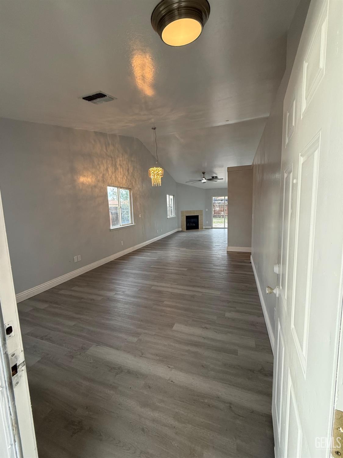 Undisclosed Address Bakersfield, CA 93313 - Photo 7 of 37 a view of an empty room with wooden floor and windows