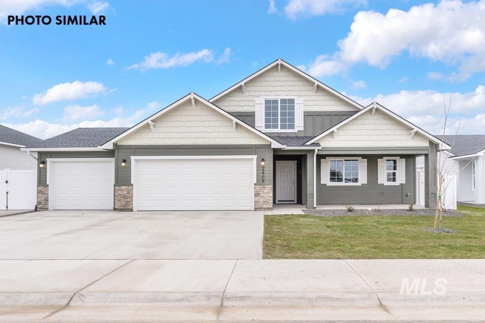 Contemporary two-story residence featuring a two-tone facade with light and dark siding, a covered front porch, an attached three-car garage, white window shutters, and a well-maintained front lawn