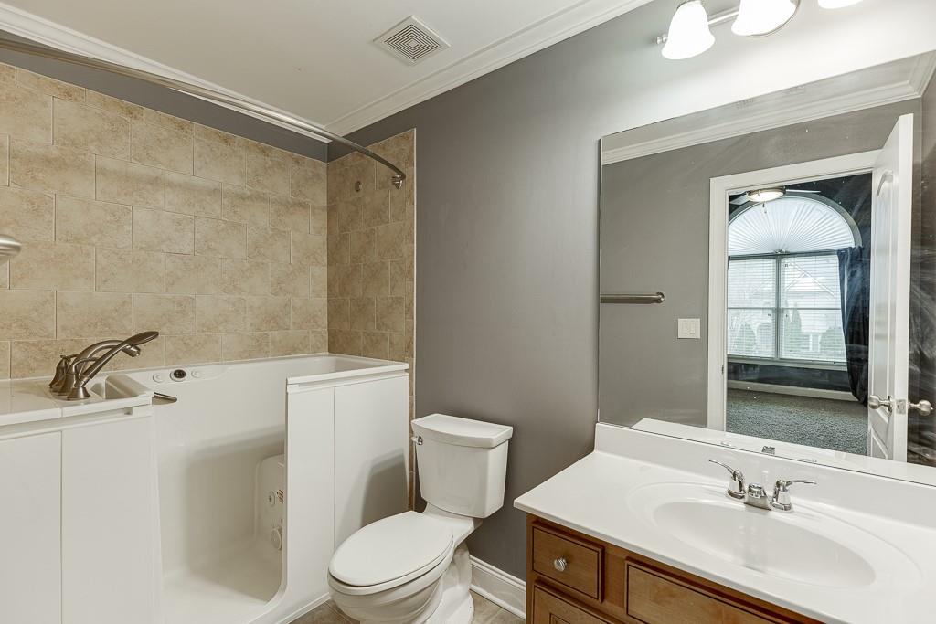 940 Chateau Forest Road Hoschton, GA 30548 - Photo 47 of 87 a bathroom with a sink toilet a mirror and shower