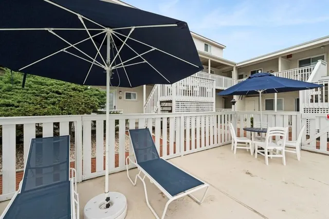 a view of a patio with table and chairs under an umbrella