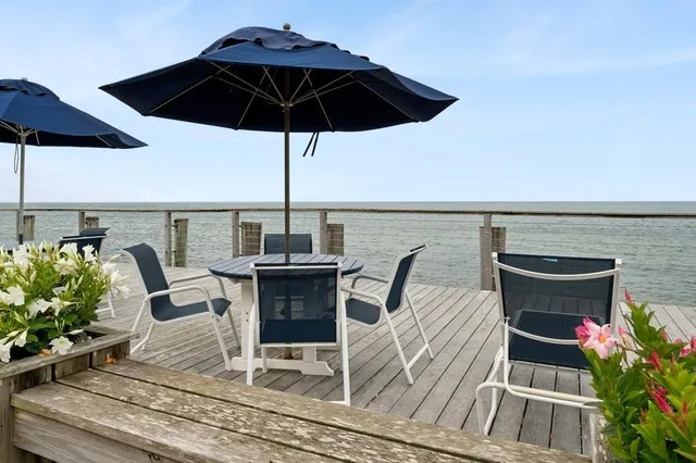 a roof deck with table and chairs under an umbrella