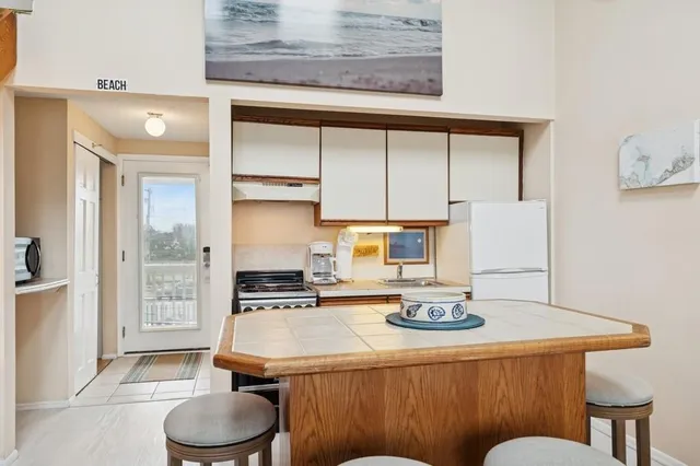 a dining room with table chairs and kitchen view