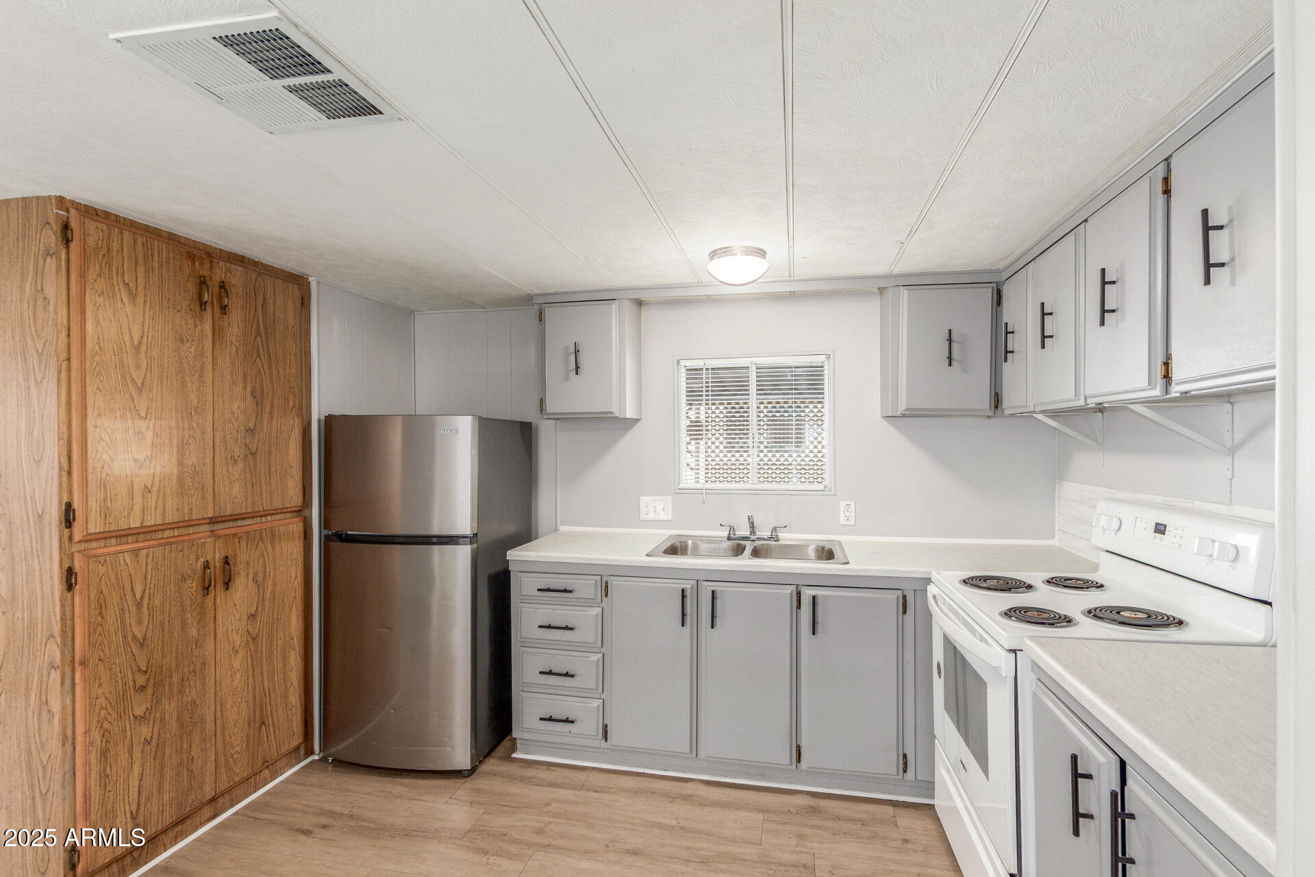 16225 North Cave Creek Road, Unit 140 Phoenix, AZ 85032 - Photo 13 of 32 a kitchen with a refrigerator sink stove and cabinets