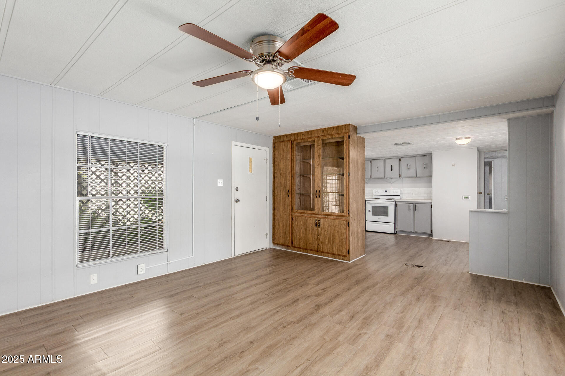 16225 North Cave Creek Road, Unit 140 Phoenix, AZ 85032 - Photo 7 of 32 a view of empty room with wooden floor and ceiling fan