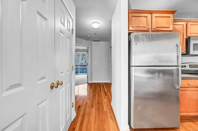 a walk in closet with wooden floor