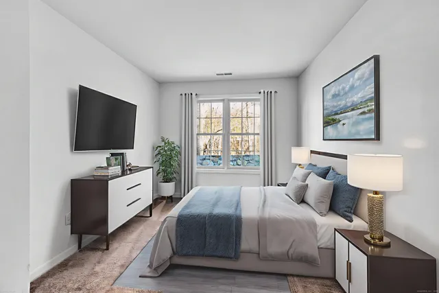 a bedroom with a bed and a flat screen television