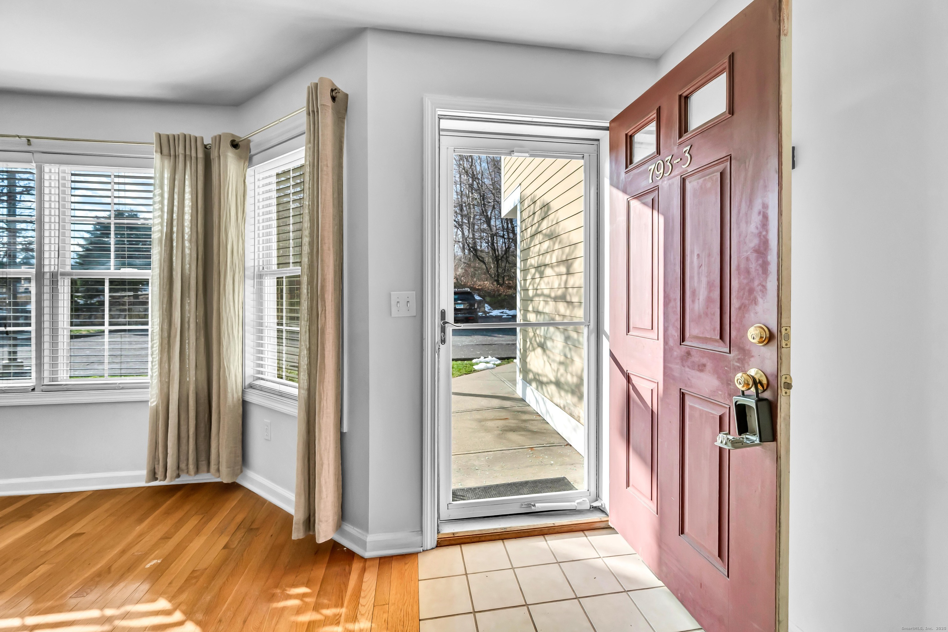 793 Federal Road, Unit 3 Brookfield, CT 06804 - Photo 25 of 30 a view of a hallway with wooden floor and a livingroom with furniture