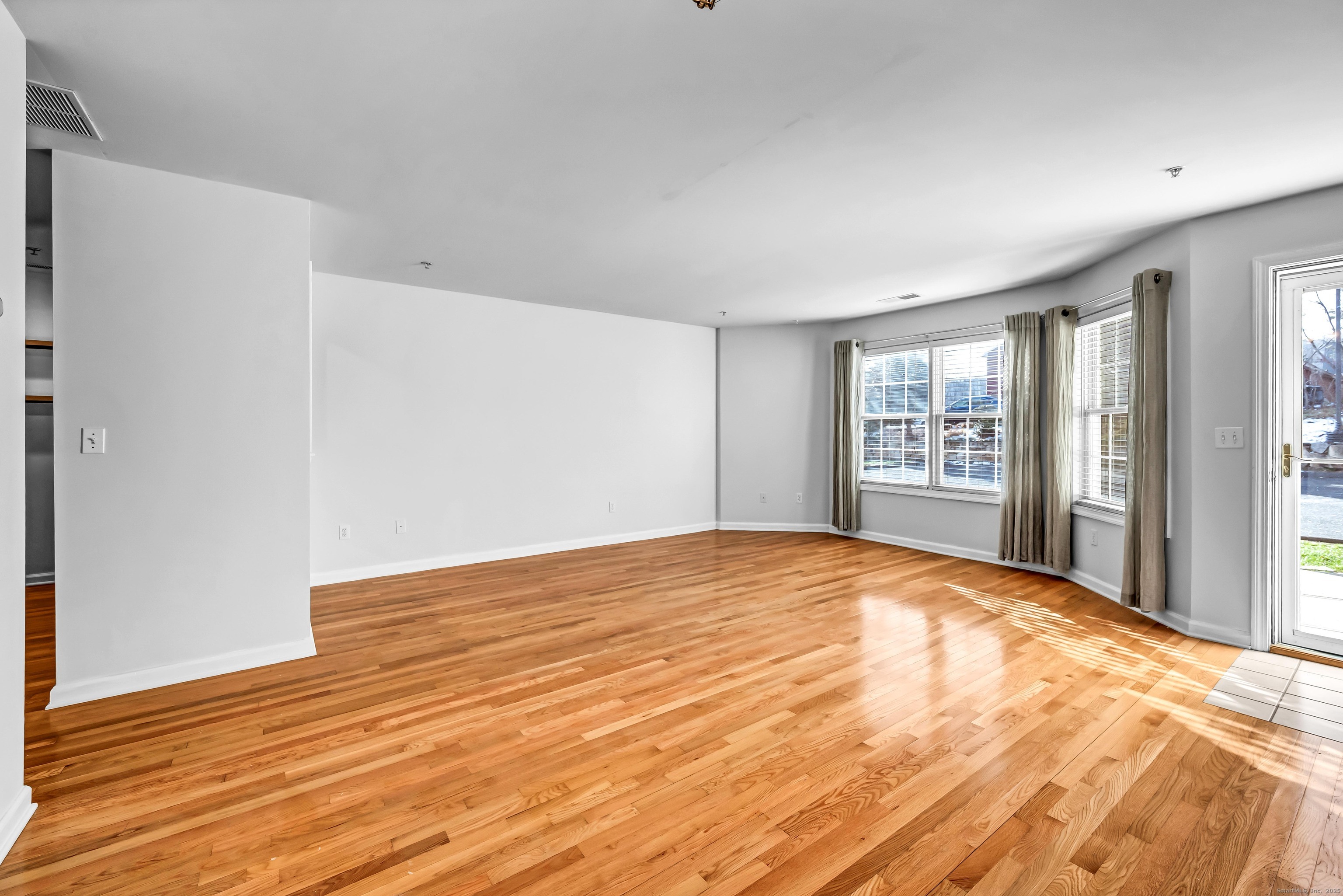 793 Federal Road, Unit 3 Brookfield, CT 06804 - Photo 6 of 30 a view of an empty room with wooden floor and a window