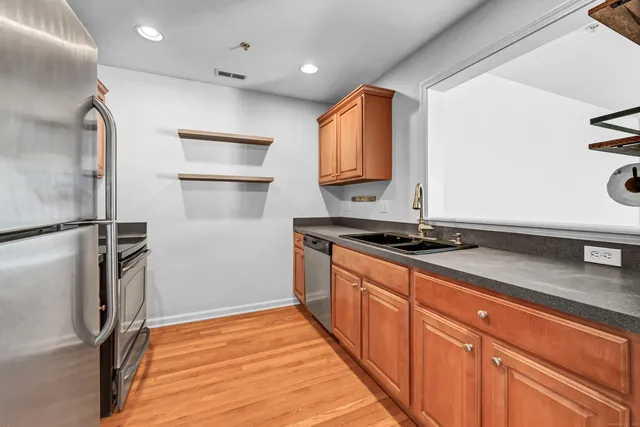 a kitchen with stainless steel appliances granite countertop a refrigerator and a sink