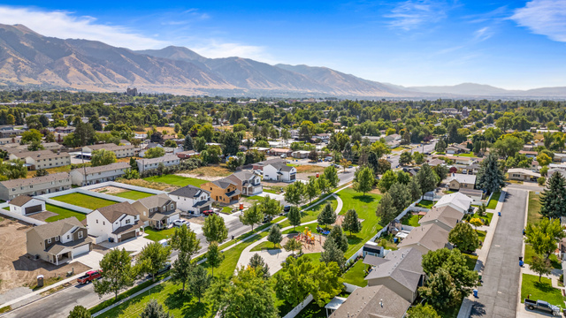 612 North 400 West Logan, UT 84321 - Photo 2 of 27 Aerial perspective of a verdant residential area featuring mountain backdrops