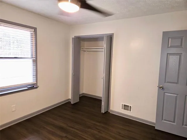 an empty room with wooden floor and window