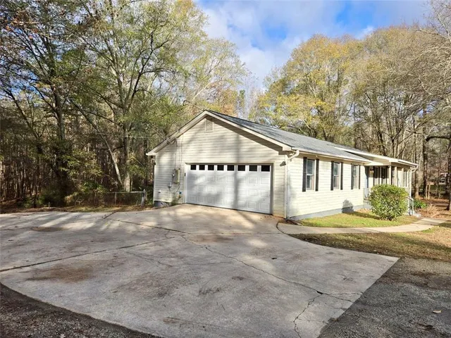 a view of large white house with a big yard and large trees